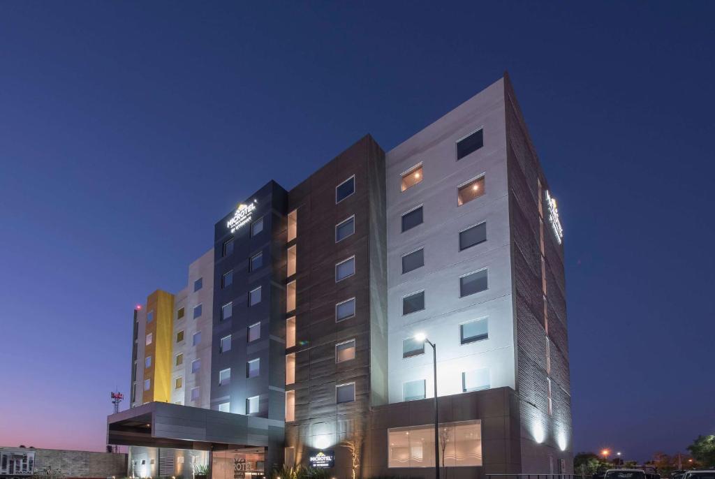 a tall white building with a lot of windows at Microtel Inn & Suites by Wyndham Guadalajara Sur in Guadalajara