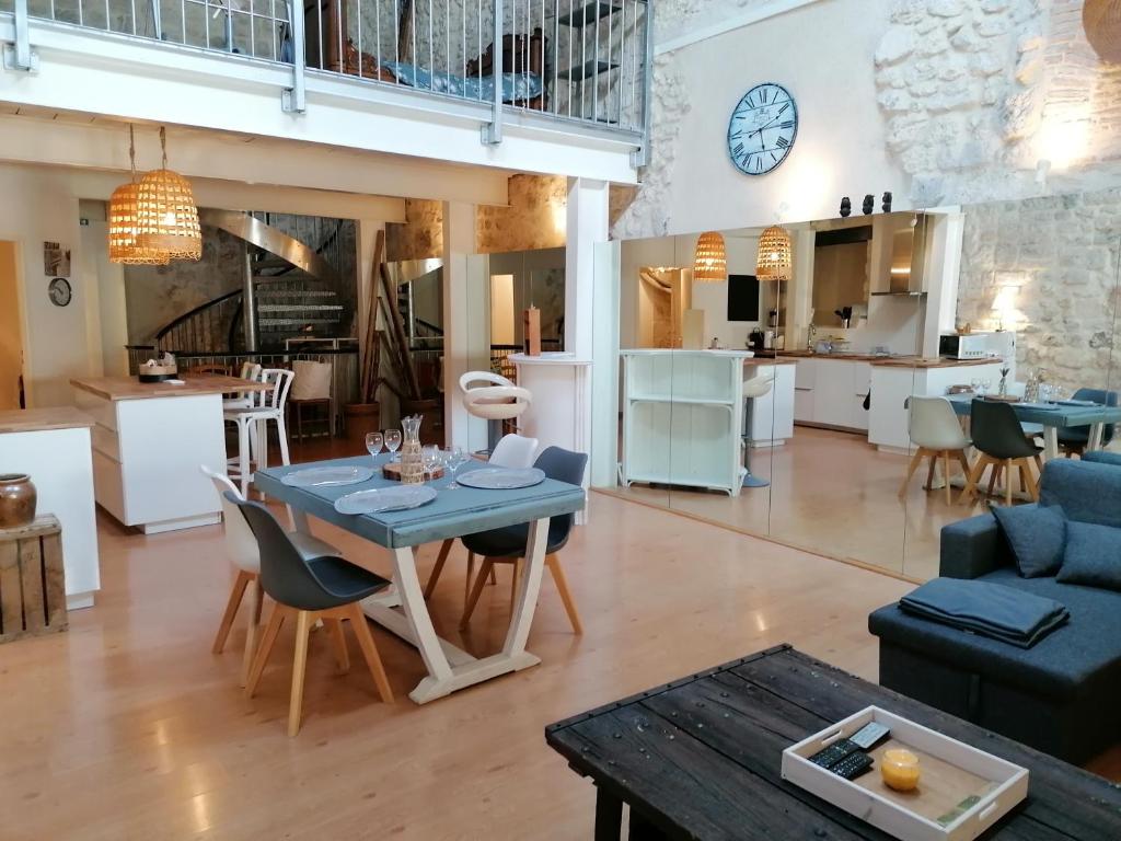 een woonkamer en een keuken met een tafel en stoelen bij LE LOFT in Casteljaloux