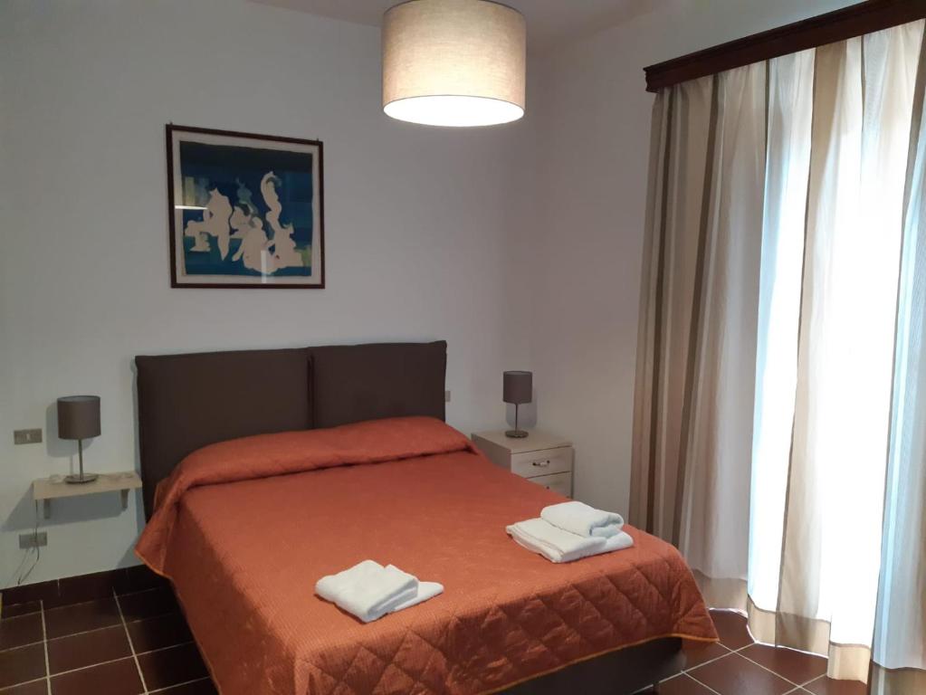 1 dormitorio con 1 cama con 2 toallas en Oikos Apartment, en Bosco
