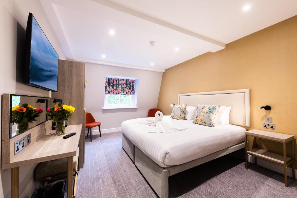 ロンドンにあるバイロン ホテルのベッド1台、薄型テレビが備わるホテルルームです。