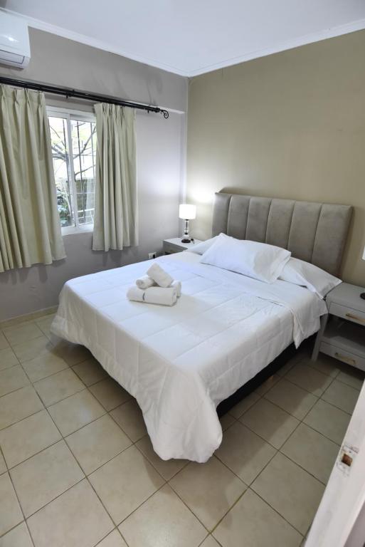 1 dormitorio con 1 cama blanca grande y toallas. en Altos de Pinamar en Ostende