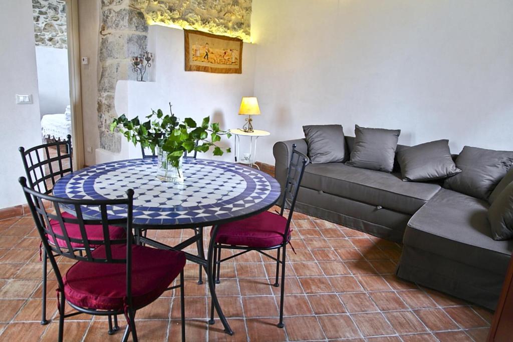 salon ze stołem, krzesłami i kanapą w obiekcie La Casa della Luna (by Vacation Service) w Cefalù