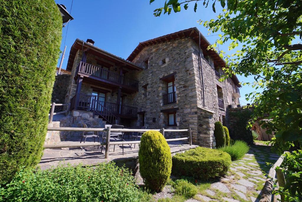 una casa de piedra con un banco delante en Gra de fajol en Girona