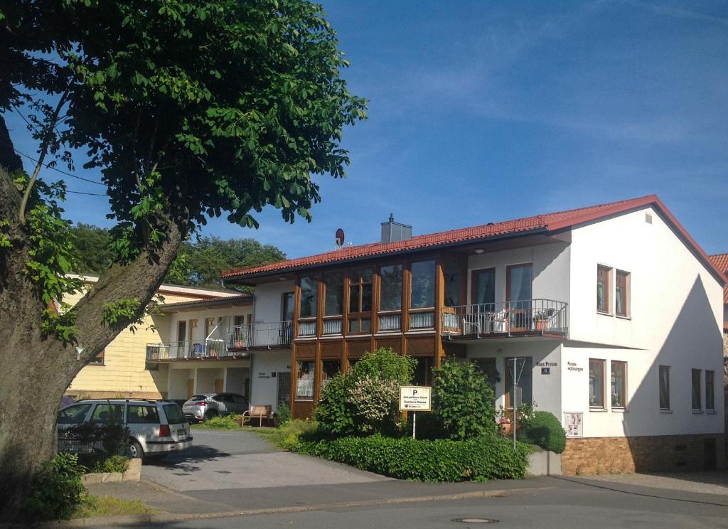 a white house with a tree in front of it at Haus Presse in Walkenried