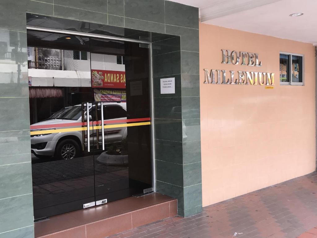 a glass door to a store with a car in it at Hotel Millenium in Labuan