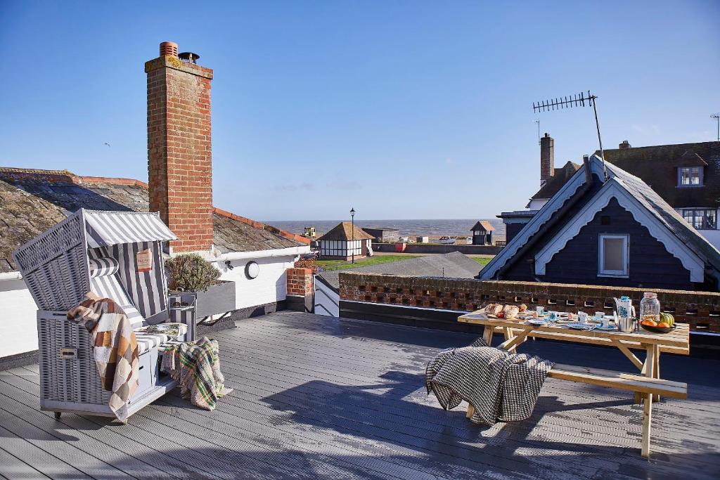 a patio with a table and a bench on a roof at SEALOFT Aldeburgh Air Manage Suffolk in Aldeburgh