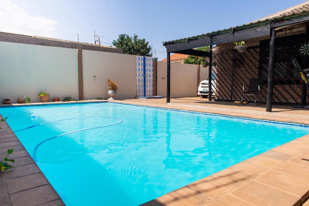 una piscina de agua azul en una casa en Casa da Noleen, en Matola
