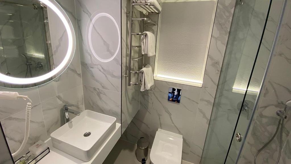 a bathroom with a shower and a sink and a mirror at Optima Collection Kamianske in Kamianske