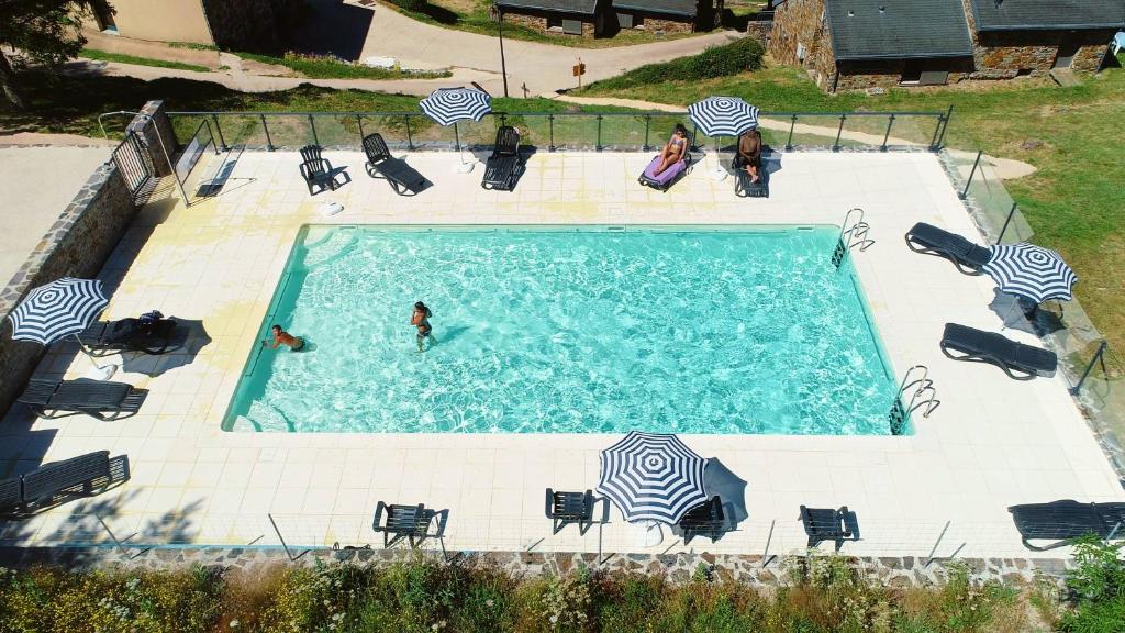 een uitzicht over een zwembad met mensen erin bij Village de gîtes de Barre-des-Cévennes in Barre-des-Cévennes