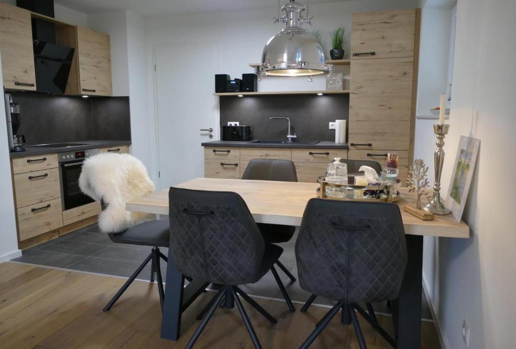 a kitchen with a wooden table and two chairs at Neue Liebe Haffkrug 1 in Haffkrug