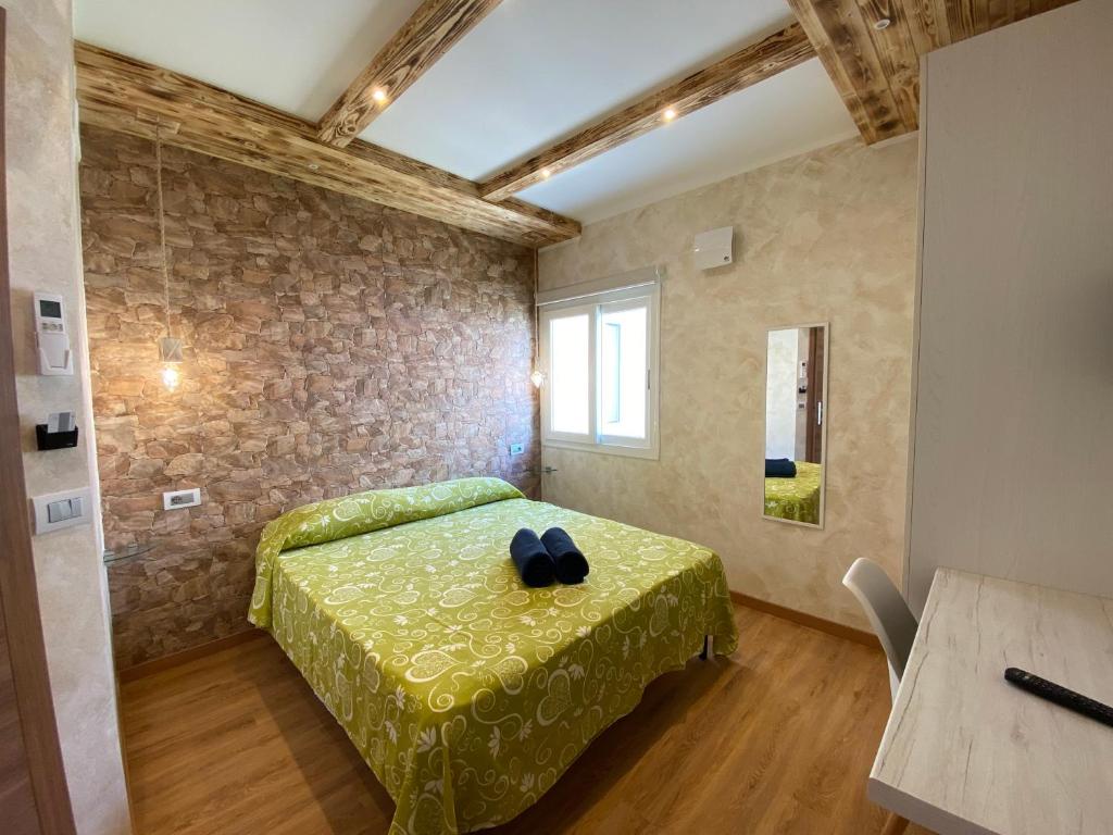 een slaapkamer met een groen bed in een kamer bij Tropea Solemare in Tropea