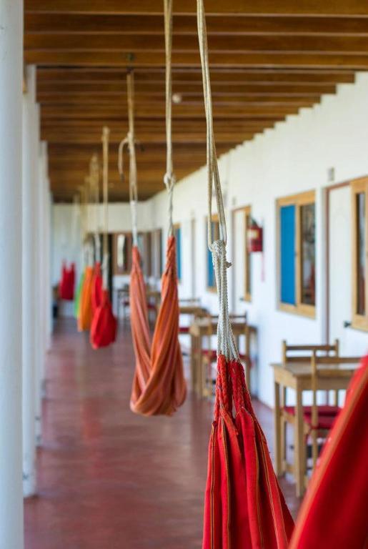 a group of red umbrellas hanging in a building at Mancora y Sol in Máncora