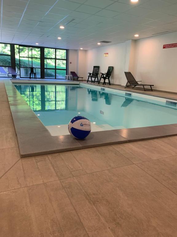a swimming pool with a volleyball in the middle at Goélia Le Domaine du Golf in Ammerschwihr