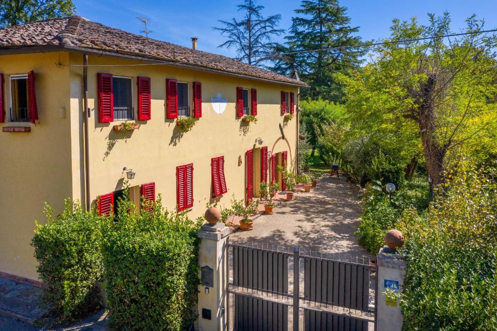 a house with red shuttered windows and a gate at Ginestraio in Santalbino by VacaVilla in Sorrezzana