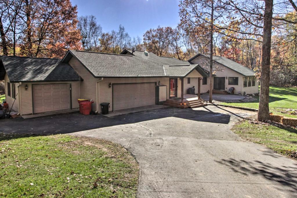 a house with a garage and a driveway at Cabin with Fire Pit and Movie Room, 1 Mi to Lake in Pequot Lakes