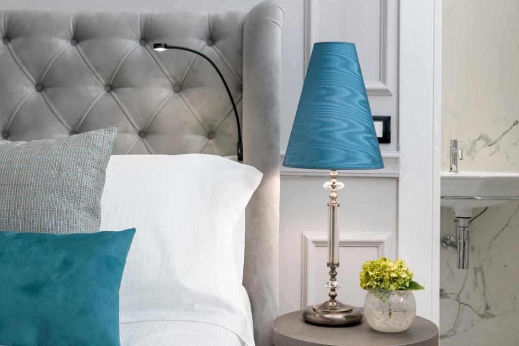 a blue lamp on a table next to a bed at Hotel La Ville Rome in Rome