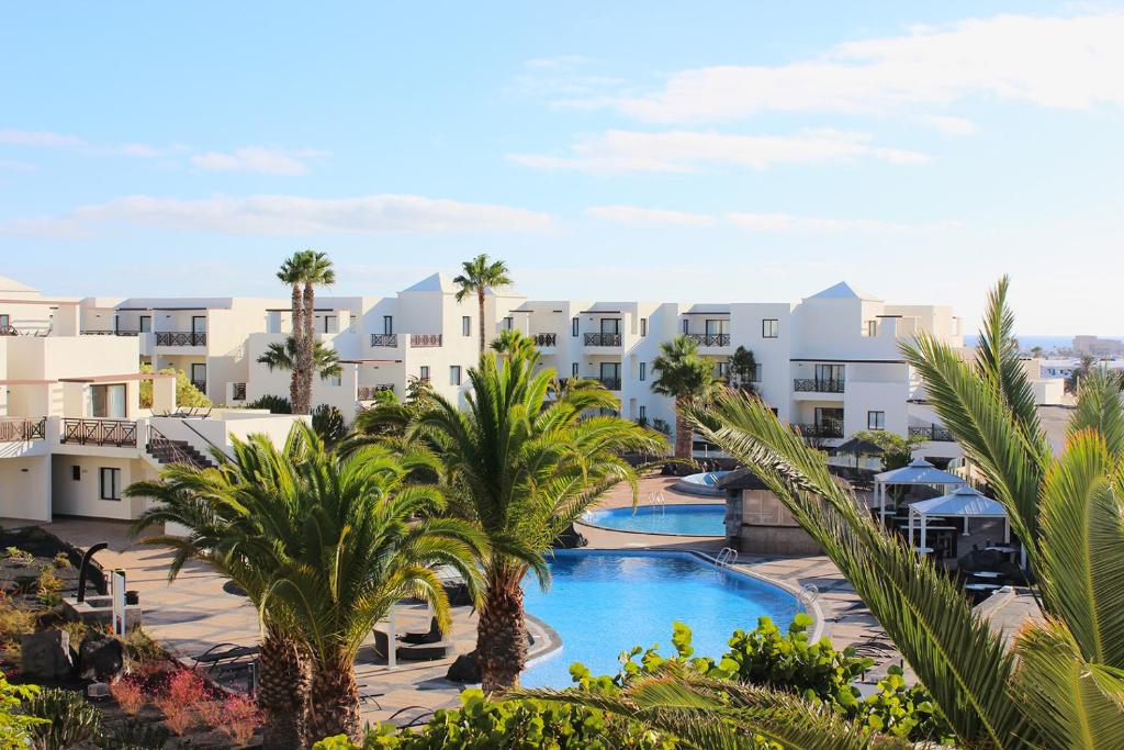 an aerial view of a resort with palm trees at Vitalclass Lanzarote Resort in Costa Teguise