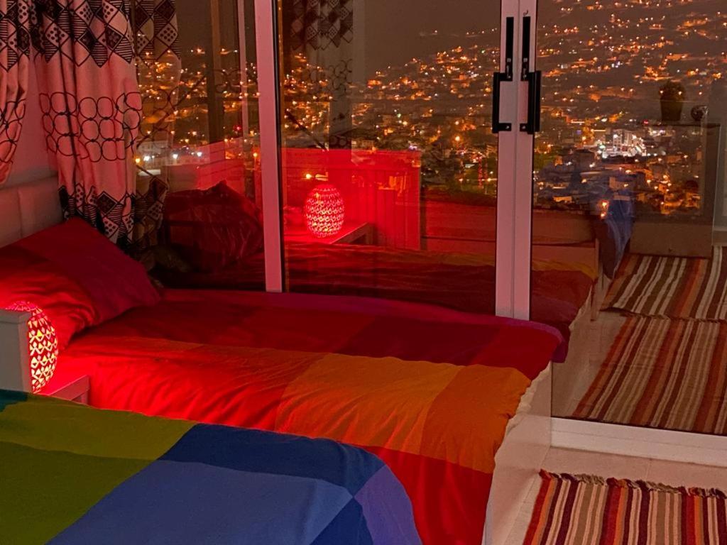 a bedroom with a colorful bed and a window with a view at Jordan Guest House in Wadi Musa