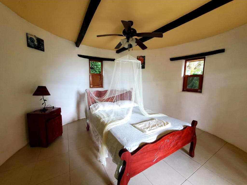 1 dormitorio con 1 cama y ventilador de techo en The Jungle, en Mérida