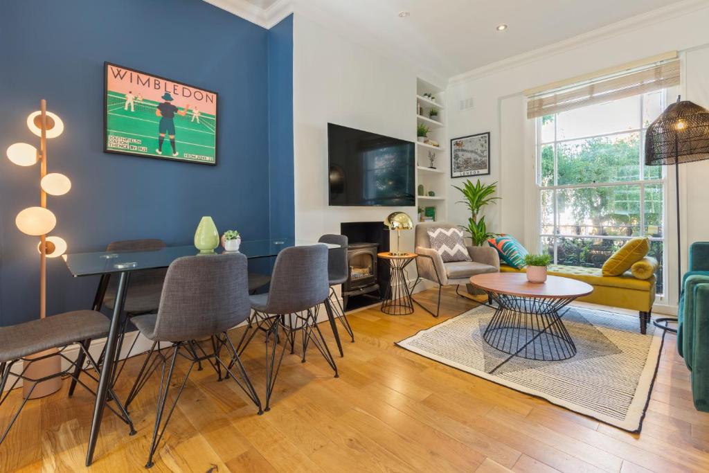 a living room with blue walls and a table and chairs at Camden Home - Barracks Properties in London