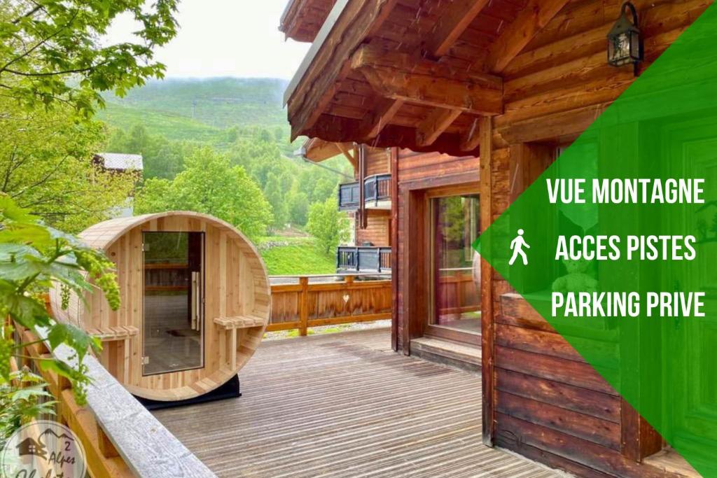 a wooden house with a large deck with a sliding door at 2AlpesChalets - Chalet Marie 2 - Standing et Sauna aux pieds des pistes in Les Deux Alpes