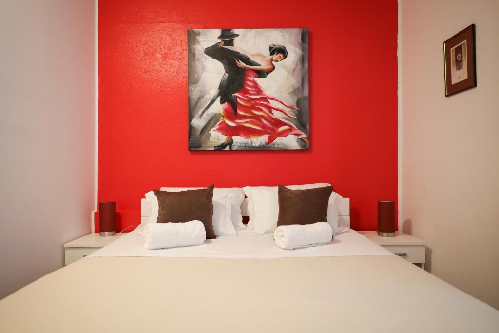 a bedroom with a bed with a painting on the wall at Rooms Goga in Zadar