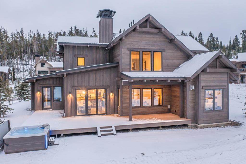 a house in the snow with a hot tub at Spanish Peaks - Highlands Cabin 45 in Big Sky