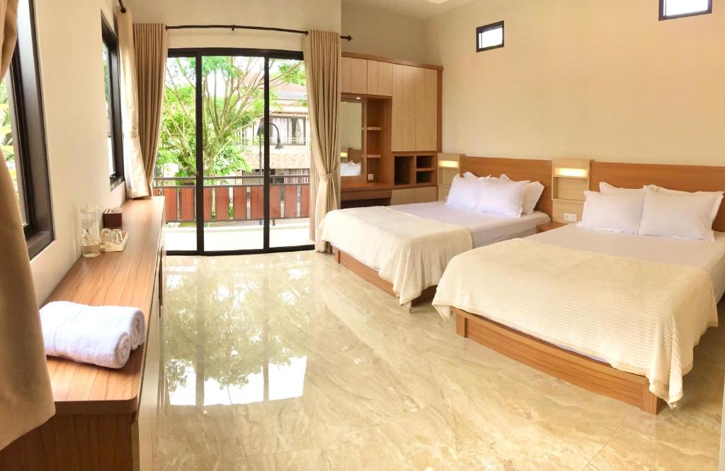 a hotel room with two beds and a balcony at Vimala Hills Villa 4 Bedroom with Mountain View in Bogor