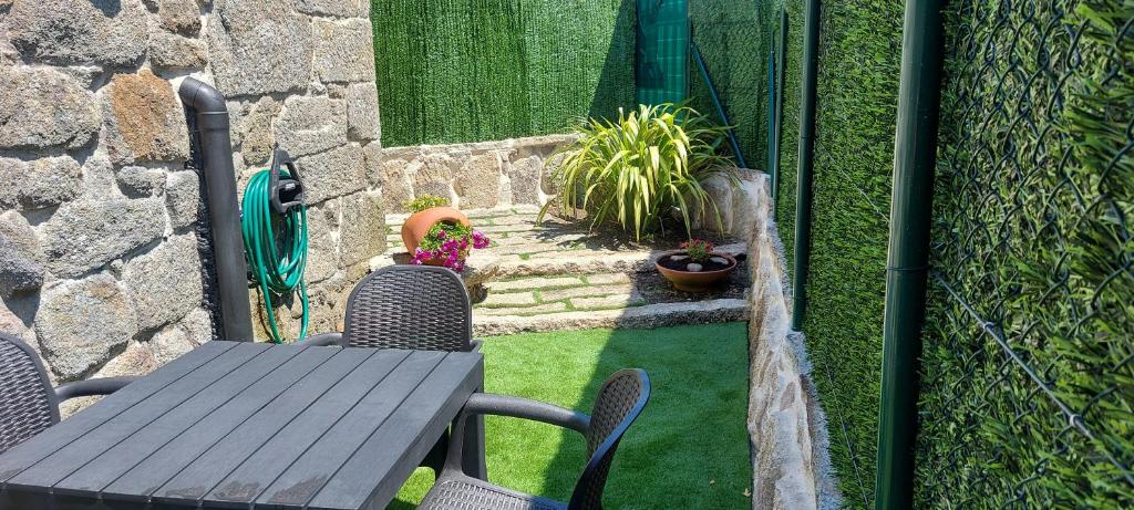 a patio with a table and chairs and a fence at Casa da Canella - En la Ribeira Sacra in Ourense
