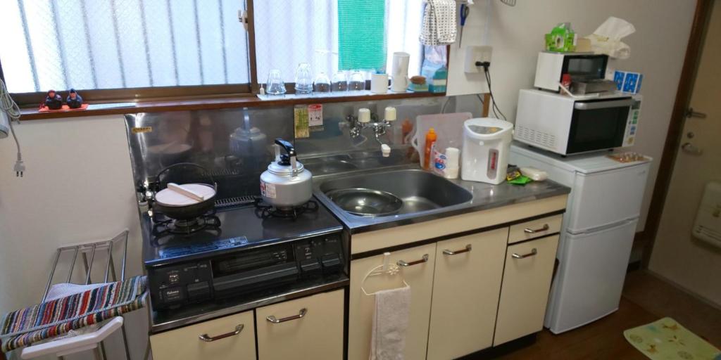 uma pequena cozinha com um lavatório e um fogão em Yagisawa Corp - Vacation STAY 90026v em Nikko