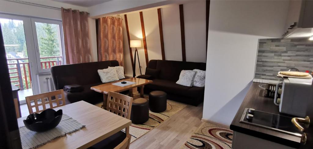 ein Wohnzimmer mit einem Sofa und einem Tisch in der Unterkunft Apartman ALTA in Vlasic