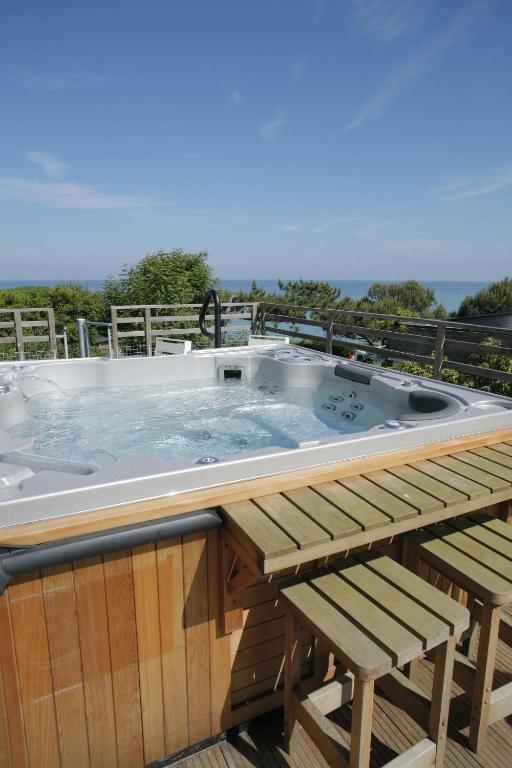a hot tub on a deck with two chairs at The Originals Hôtel Le Cise Restaurant Chambres et Suites in Ault