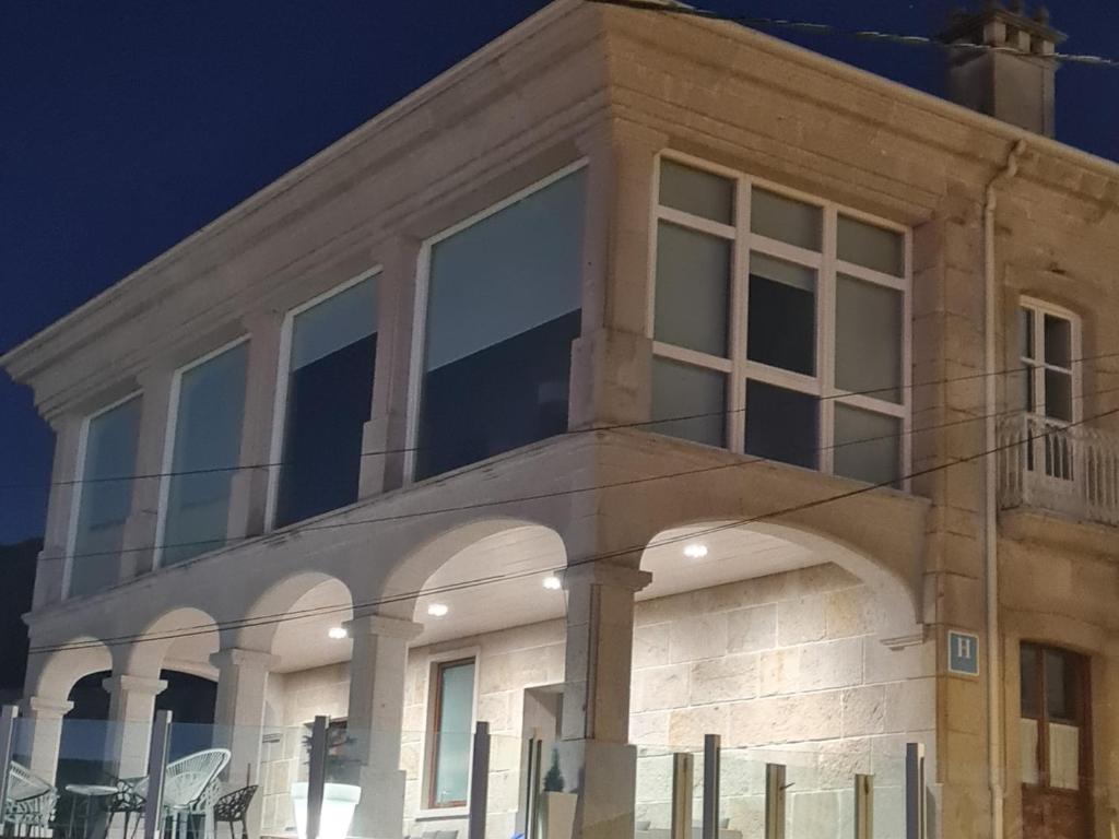 un edificio con ventanas grandes en un lateral en Casa Grand Galicia, en Junquera de Espadañedo