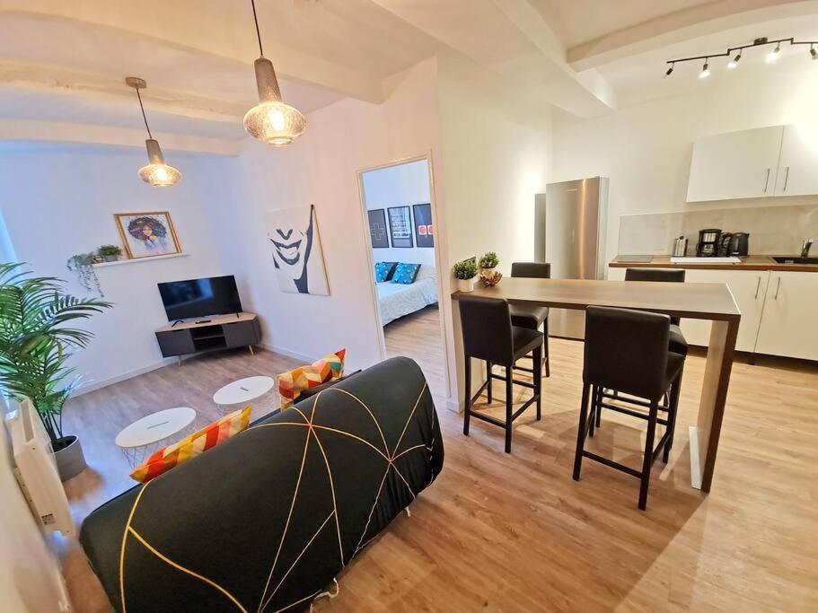 a living room with a couch and a table with chairs at GregBnb-com - T2 Design 43m2 - Toulon Est - Wifi Fibre - n2 in Toulon