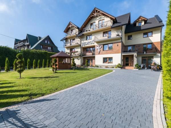 a large apartment building on a cobblestone street at OW JĘDRUŚ in Zawoja