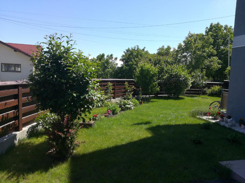 een achtertuin met een hek en groen gras bij Untold 2024 - 3-room apartment with garden for 6-8 person, 2 private parking in Cluj-Napoca