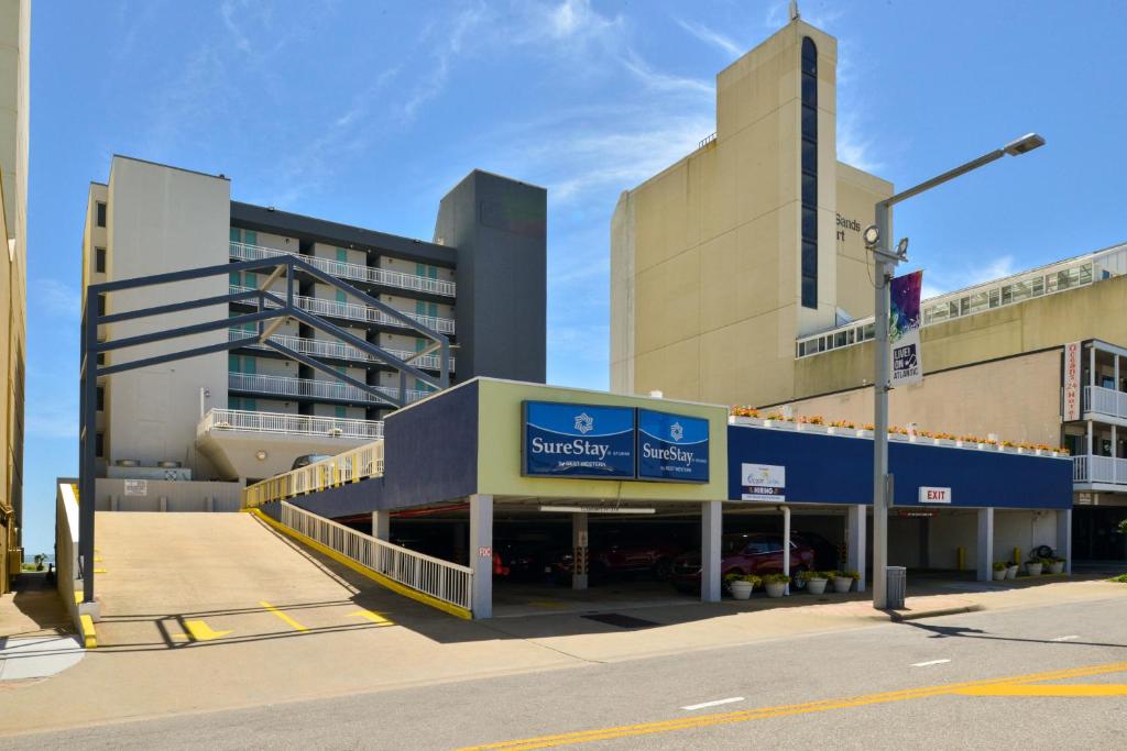 un grand bâtiment avec un panneau devant lui dans l'établissement SureStay Studio by Best Western Virginia Beach Oceanfront, à Virginia Beach