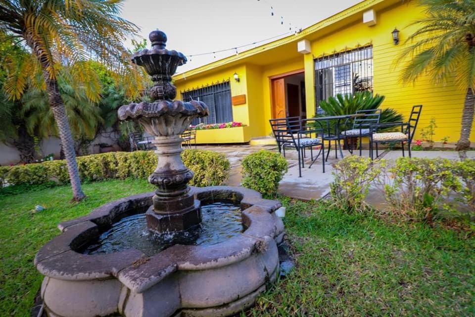 una fuente en el patio de una casa amarilla en Hotel Franco, en El Fuerte