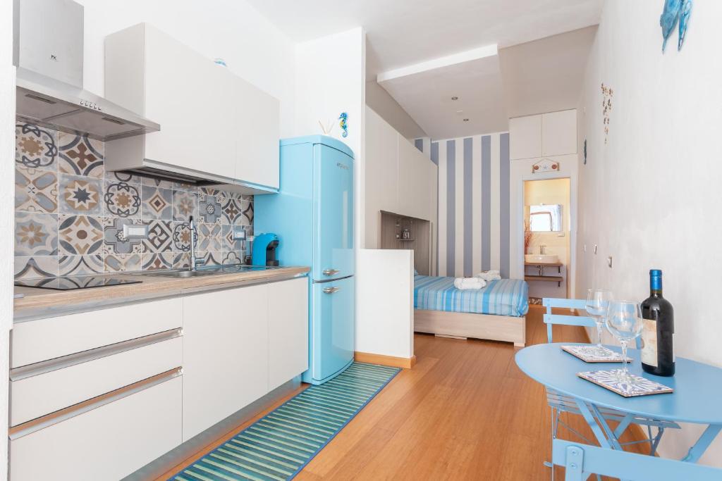 Il comprend une cuisine équipée d'une table et d'un réfrigérateur bleu. dans l'établissement SAILING, à Cagliari