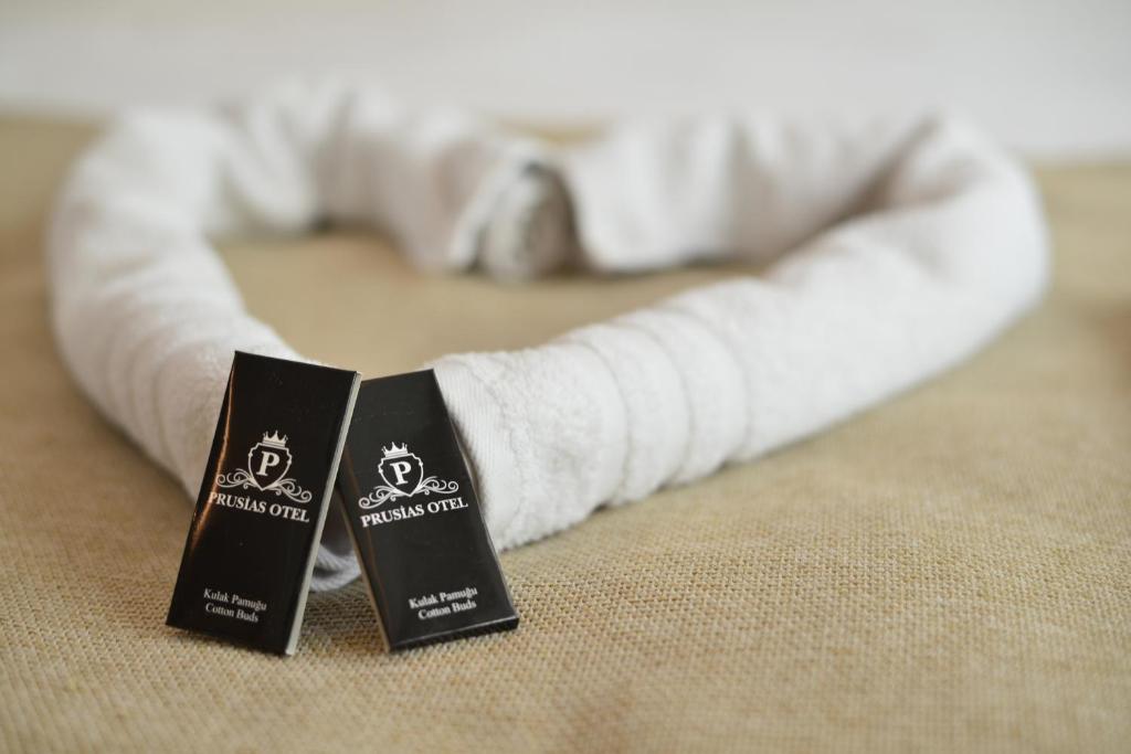two black signs sitting on top of a bed at Prusias Otel in Bursa