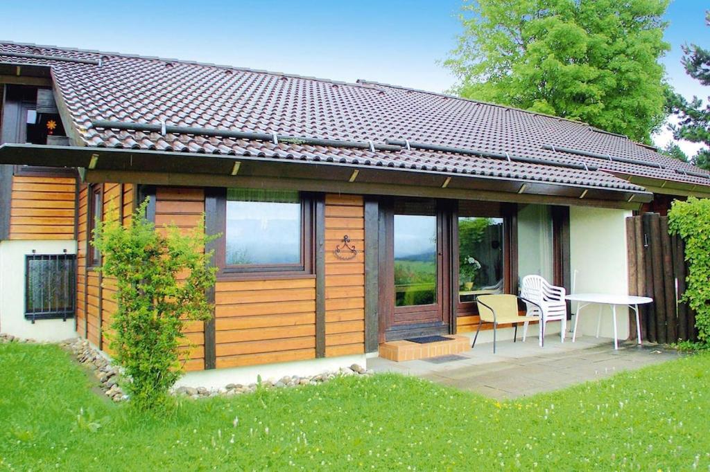 een klein huis met een tafel en stoelen op een patio bij Holiday resort fingen Bad D rrheim in Bad Dürrheim