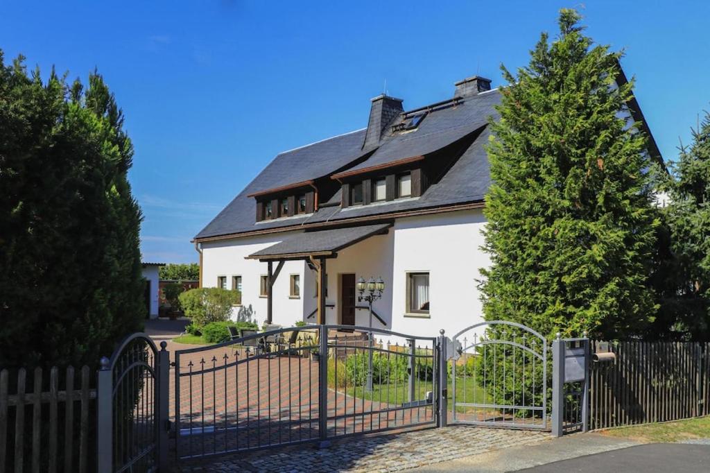 a white house with a black roof and a gate at Apartment view of fortress in Pirna in Pirna