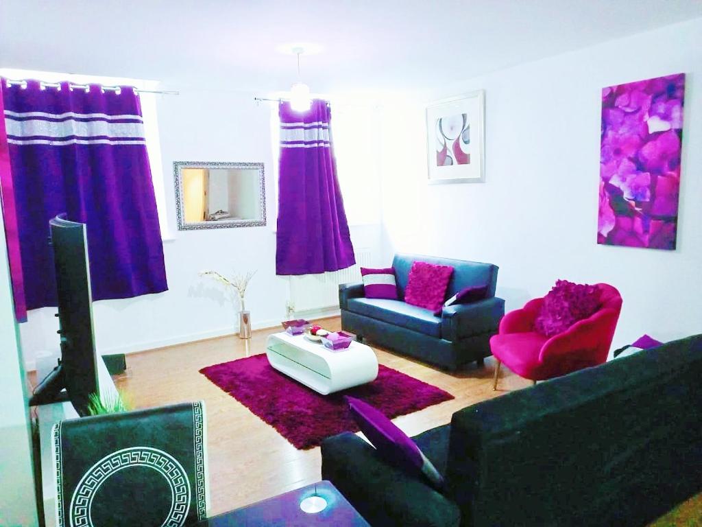 sala de estar con muebles de color púrpura y TV en DOUBLE ROOM CLOSE TO BRADFORD UNIVERSITY AND CITY CENTRE en Bradford
