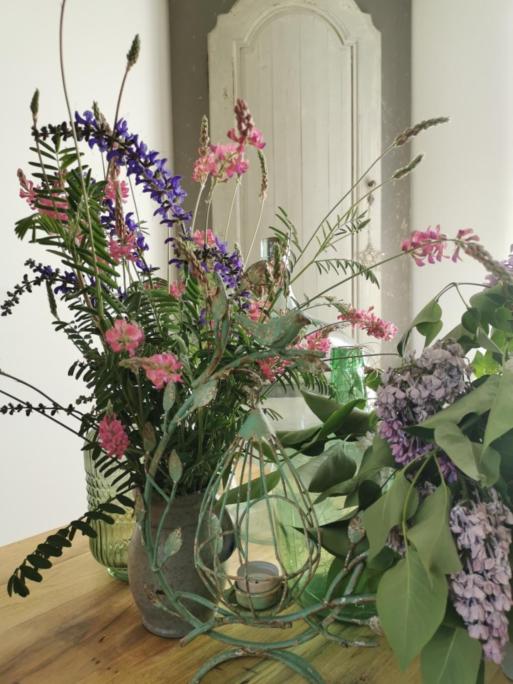 un vase en verre rempli de fleurs sur une table dans l'établissement Petit Nid, à Strasbourg