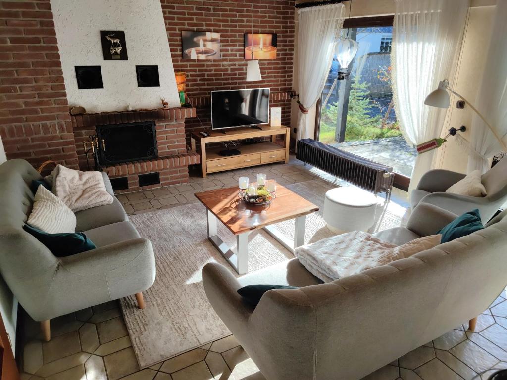 sala de estar con 2 sofás y chimenea en Villa Rose en Altenau