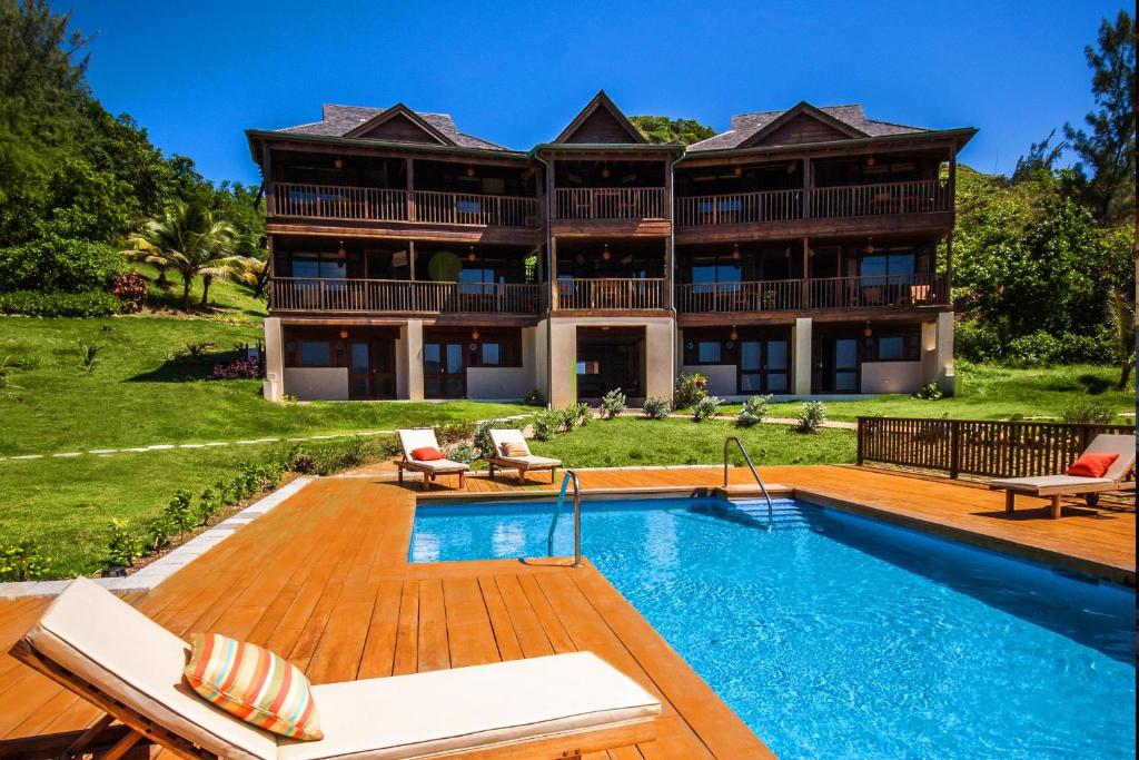 a house with a swimming pool in front of it at Santosha Barbados in Saint Andrew