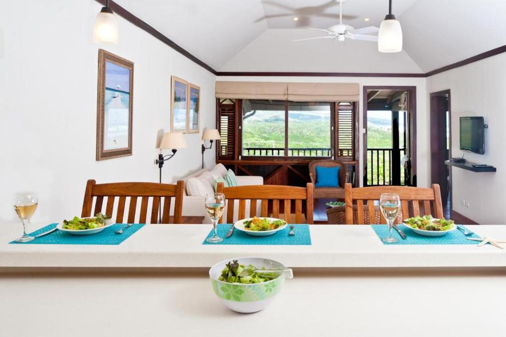 a kitchen and living room with a table with two plates of food at Santosha Barbados in Saint Andrew
