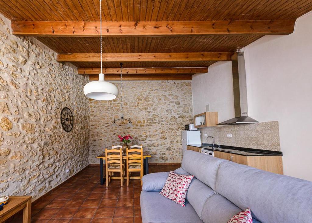 a living room with a blue couch and a table at Habitour - Casa Palmira in Cervera del Maestre