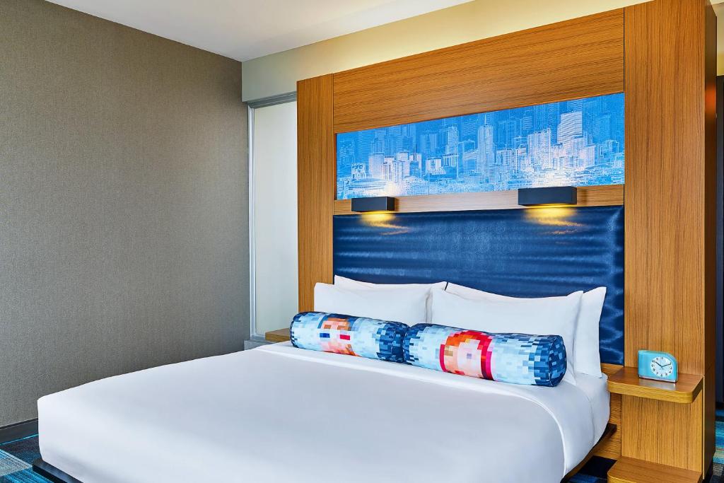 a large white bed in a hotel room at Aloft Denver Airport at Gateway Park in Aurora