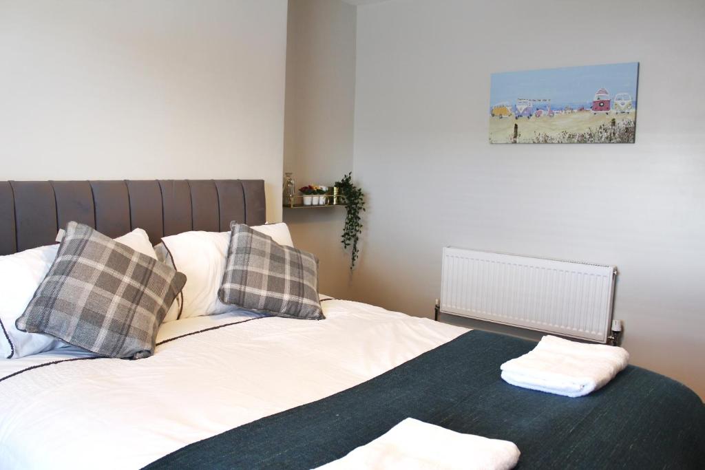 a bed with two pillows and a blanket on it at Jerry's Apartment Blue in Kent